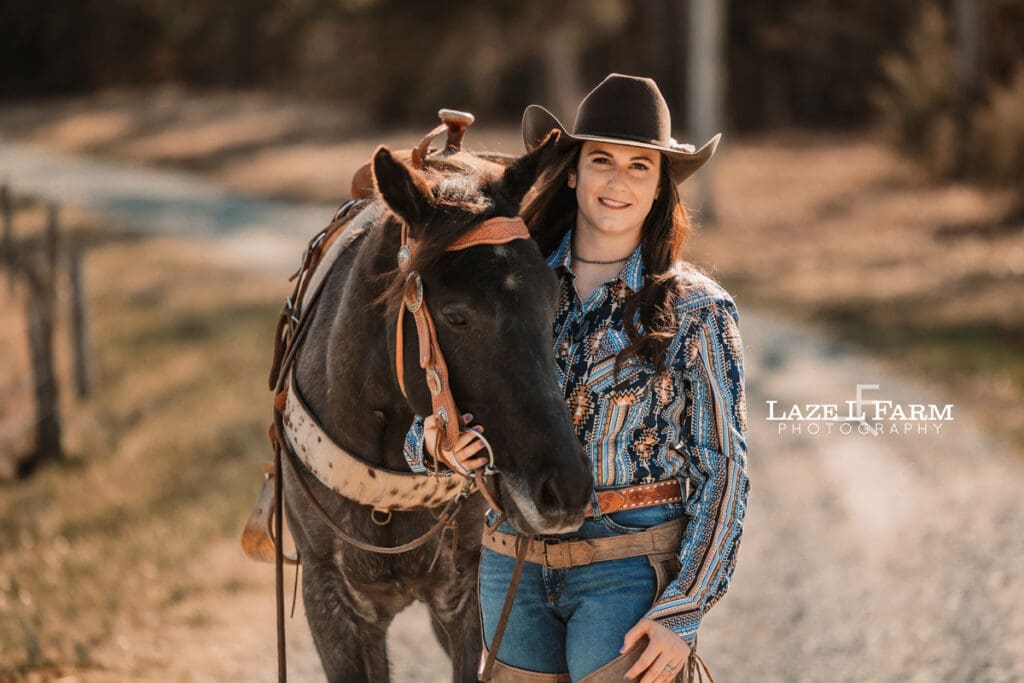 cowgirl standing beside her horse