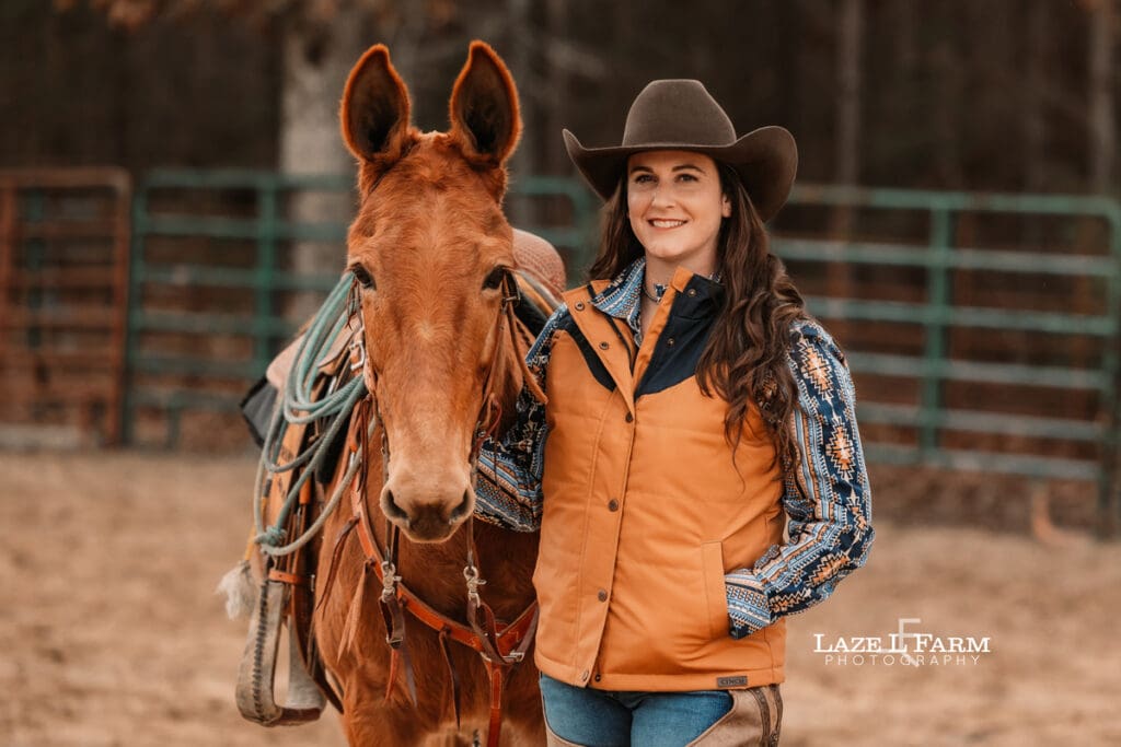 cowgirl standing beside her mule