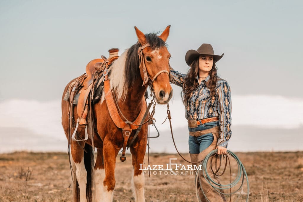 cowgirl standing beside her horse