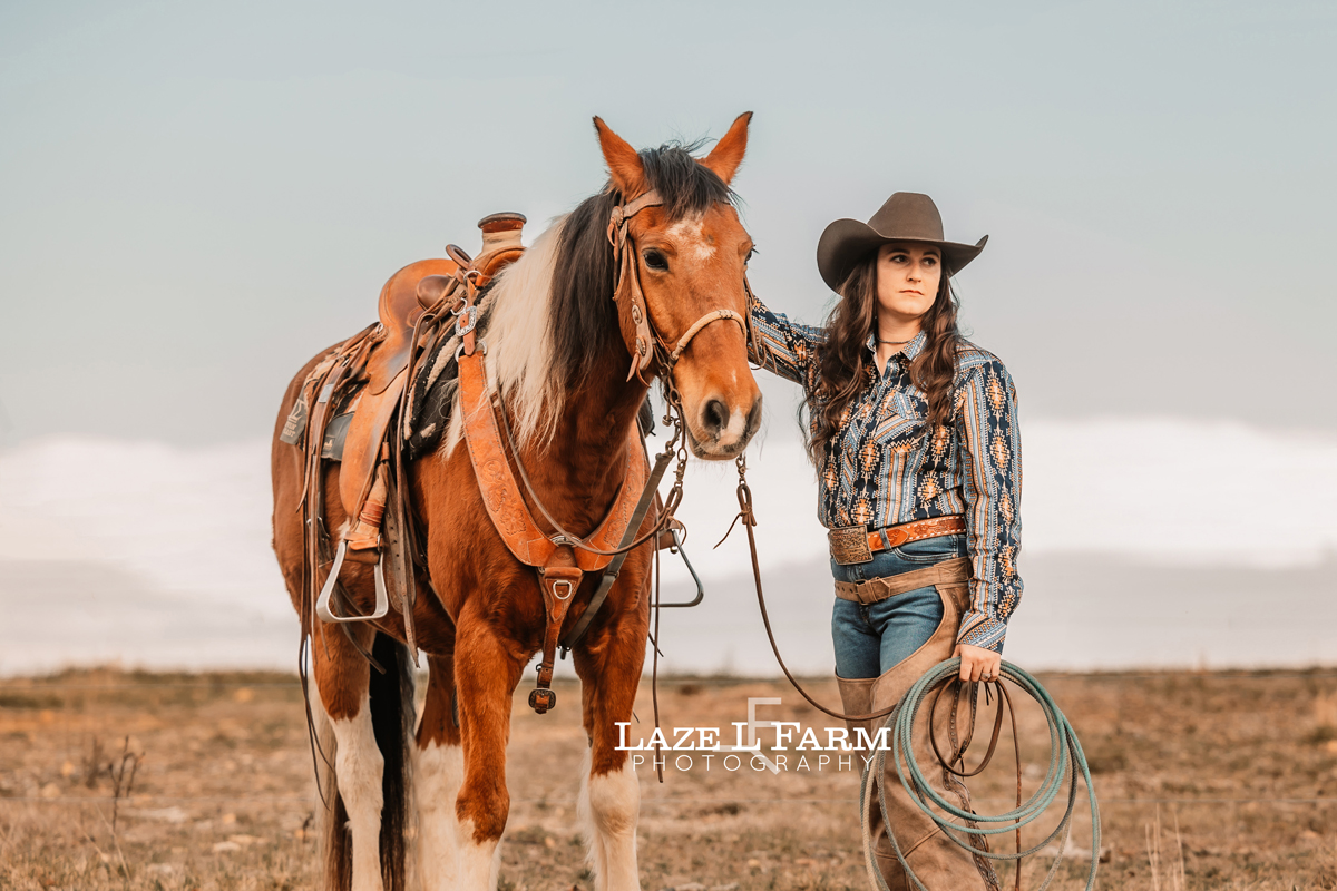 cowgirl standing beside her horse