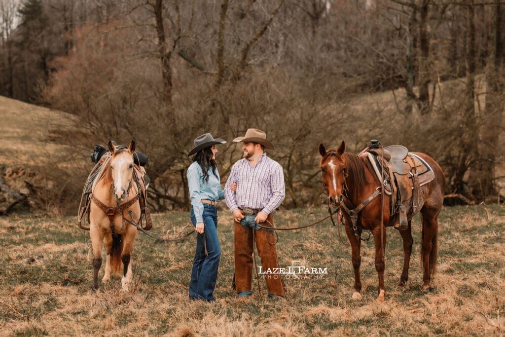 cowboy and cowgirl with horses standing beside of each other