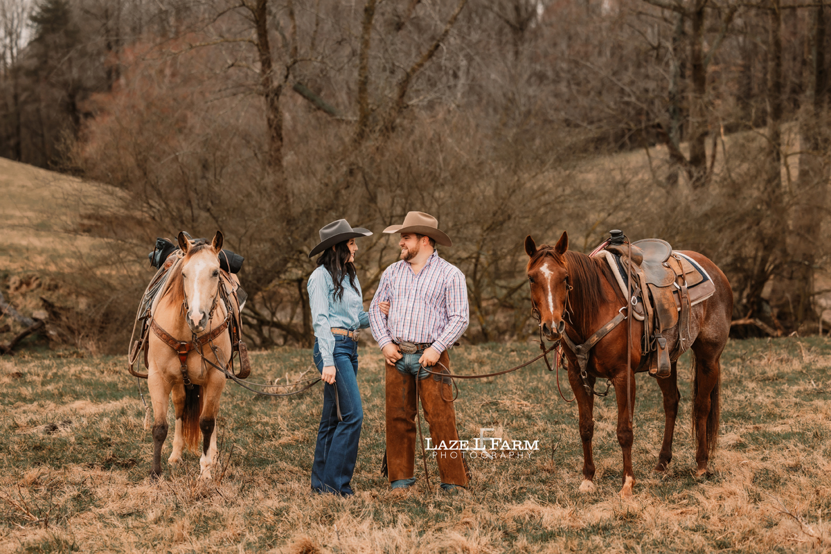 cowboy and cowgirl with horses standing beside of each other