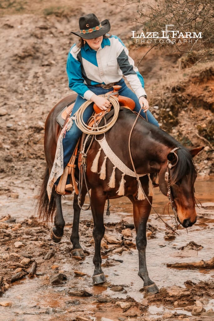 cowgirl and her horse crossing the creek