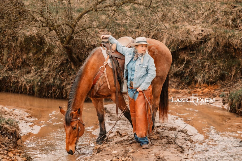 cowgirl and her horse in the creek