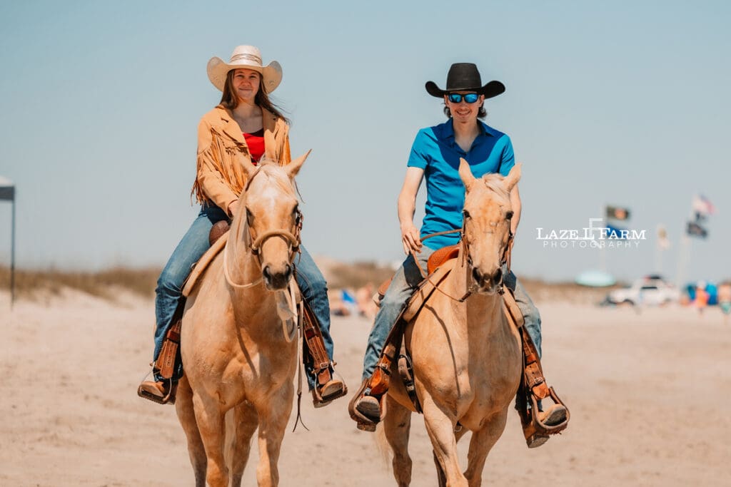 western couple riding horses on the beach