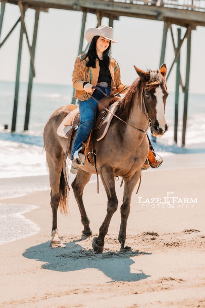 cowgirl riding her horse on the beach