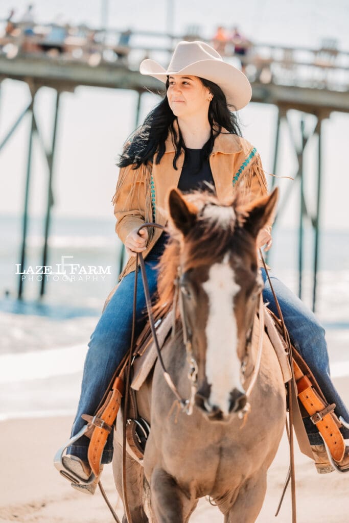 cowgirl riding her horse on the beach