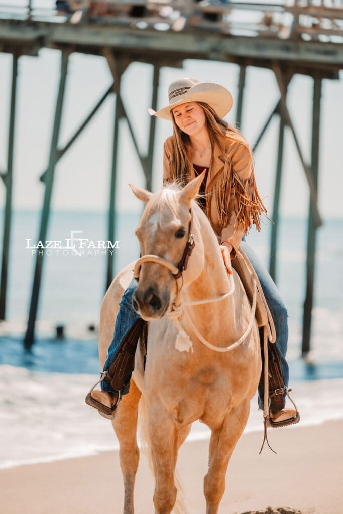 cowgirl riding her horse on the beach