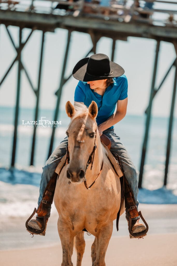 cowboy riding her horse on the beach