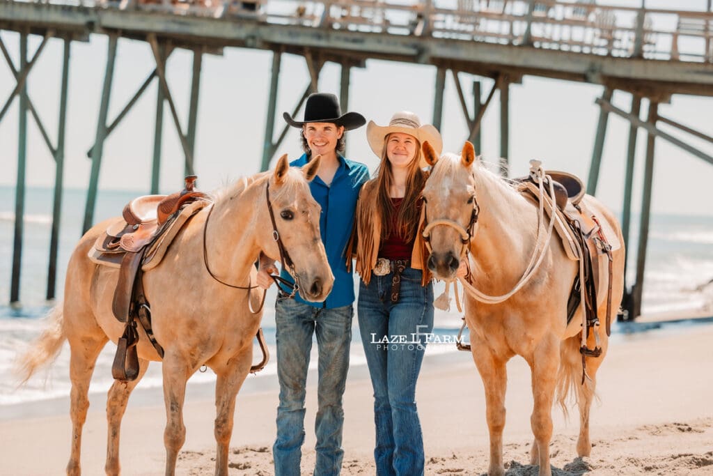 western couple with their horses on the beach