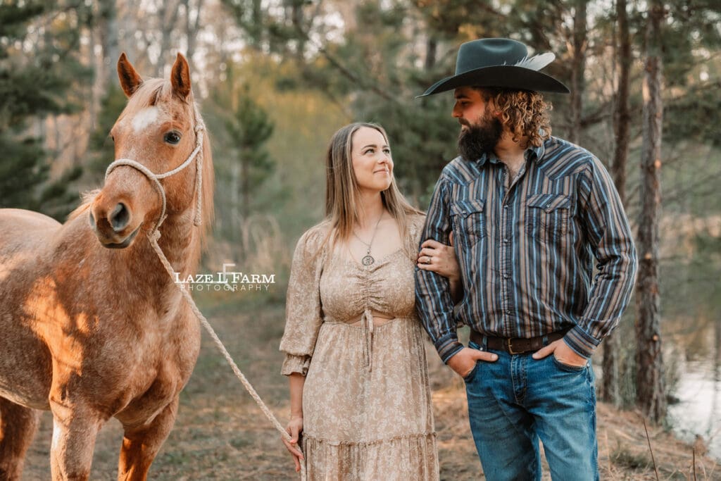 western couple standing with horse