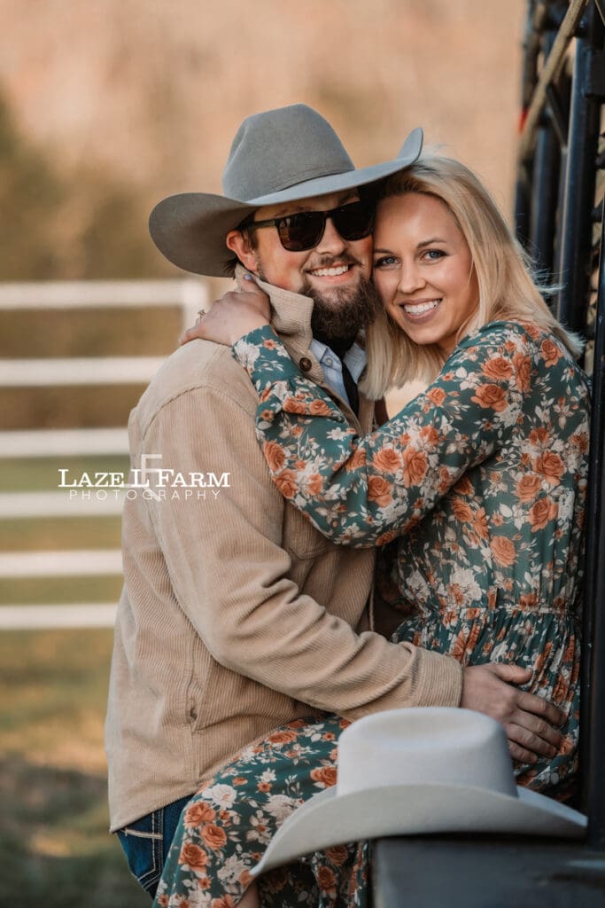 couple sitting on the side of a horse trailer