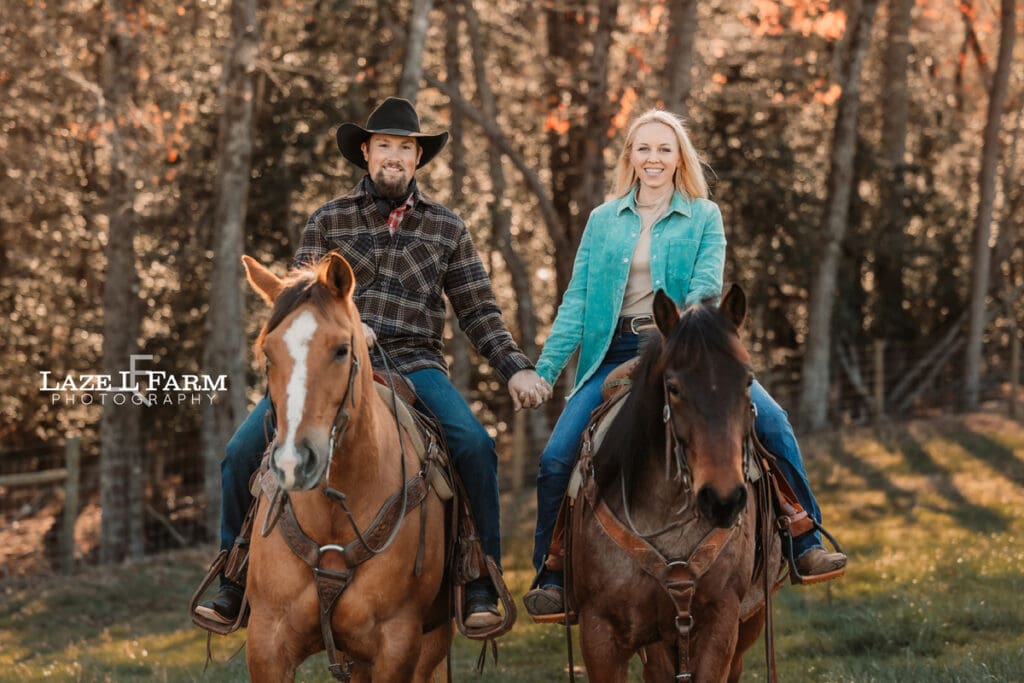 couple holding hands riding horses