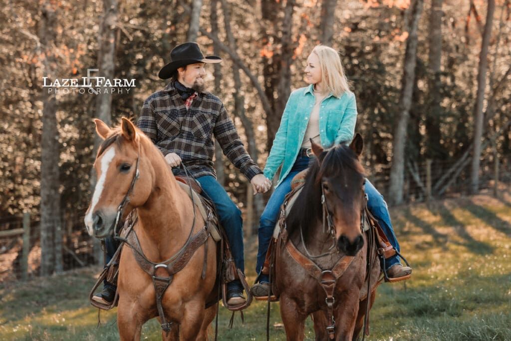 couple holding hands riding horses