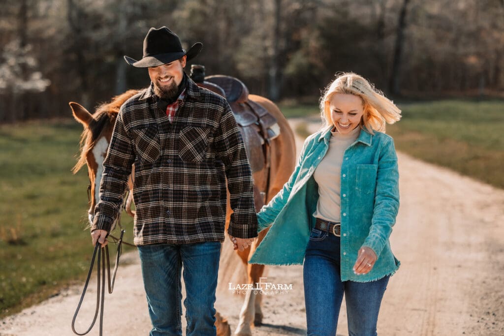 couple holding hands and walking with horse