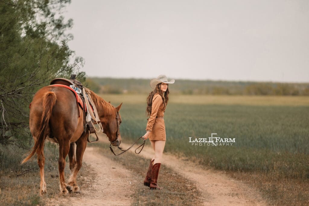 cowgirl walking away with her horse