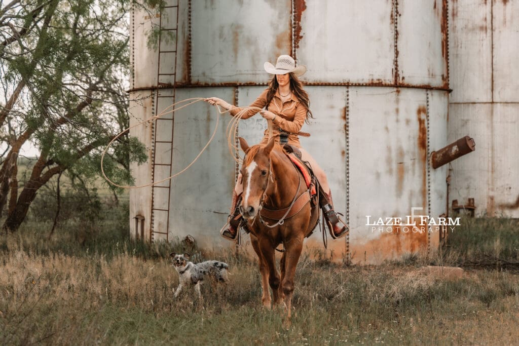 cowgirl riding her horse swinging a rope