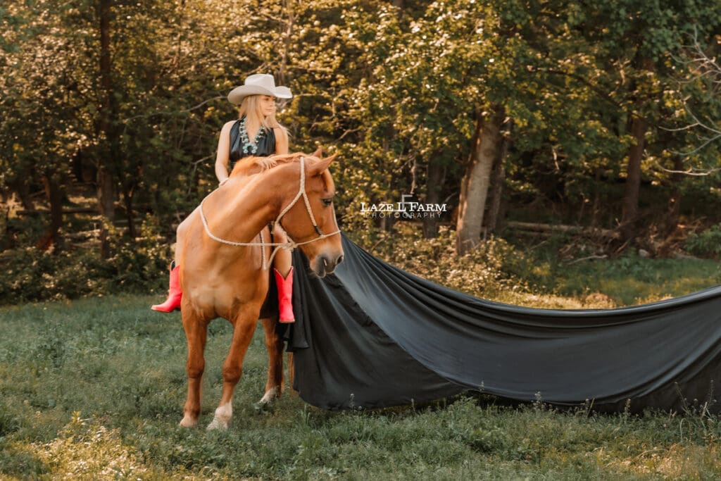 girl in a black parachute dress on the back of a horse