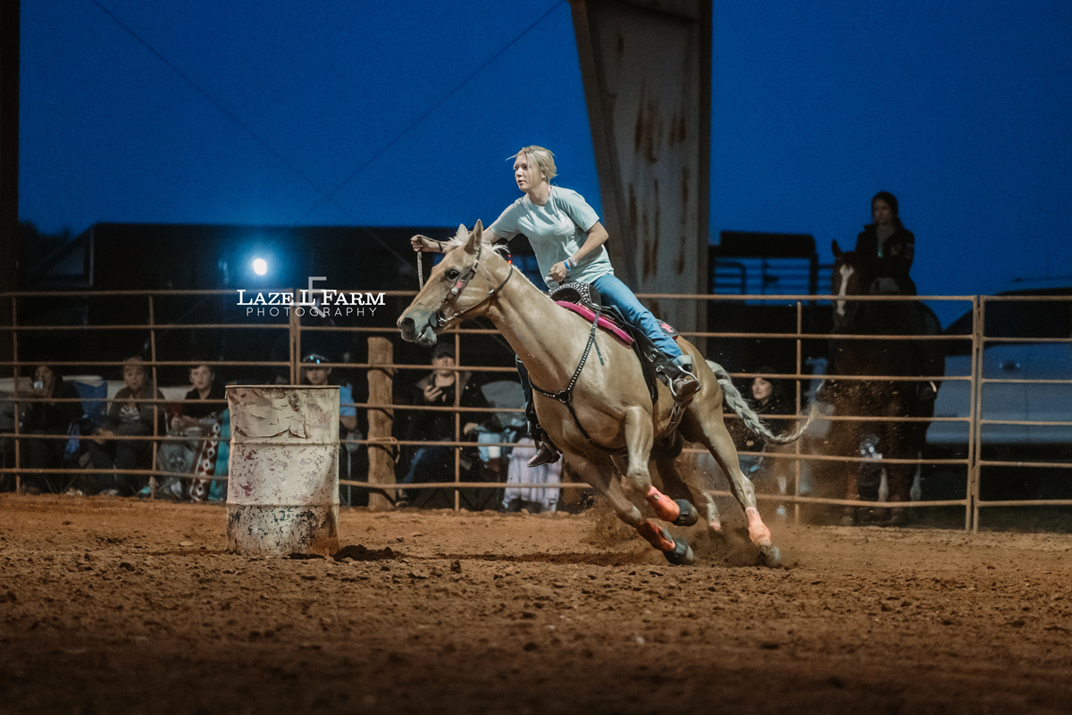 cowgirl barrel racing on a palomino horse