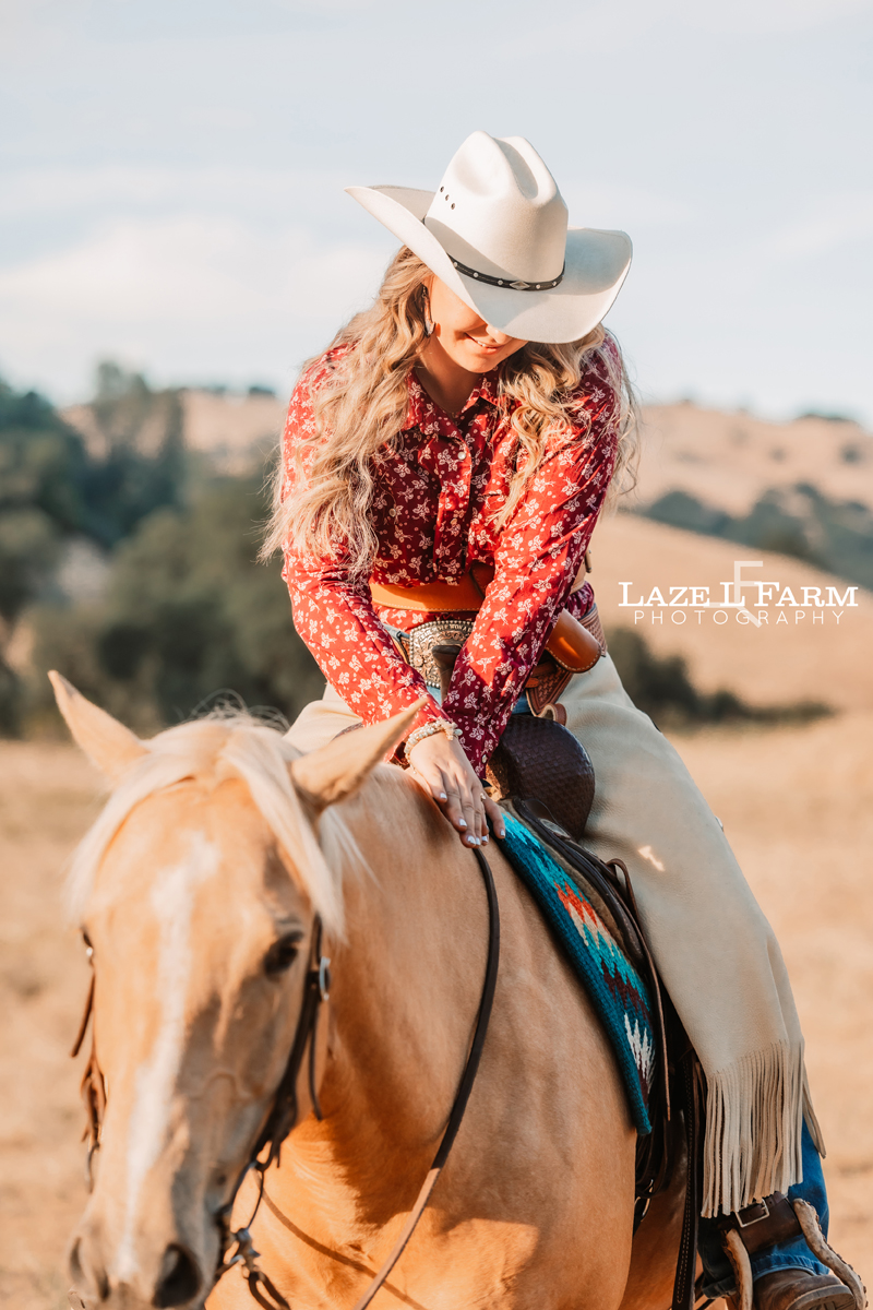 cowgirl petting her horse on the neck