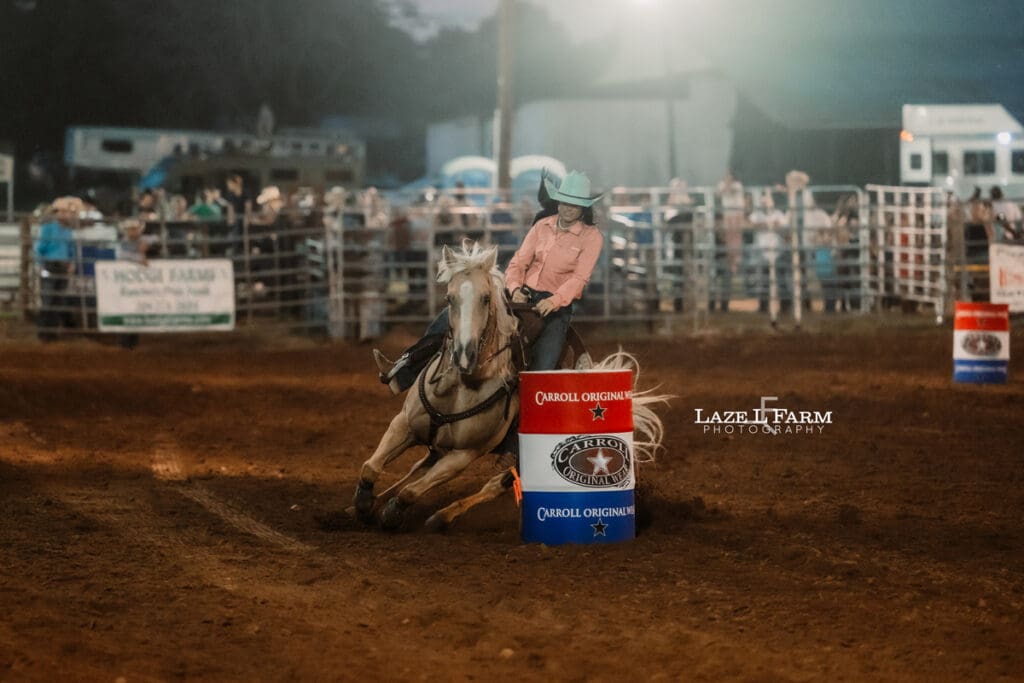 cowgirl on a palomino horse barrel racing at the Cleveland Rodeo while Laze L Farm Photography takes pictures