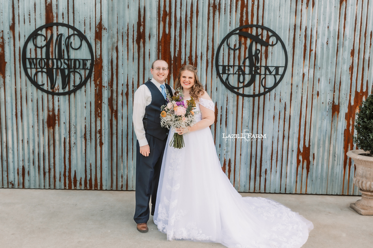 Bride and Groom standing in front of their wedding venue at Woodside Farm in Graham, NC pictures by Laze L Farm Photography