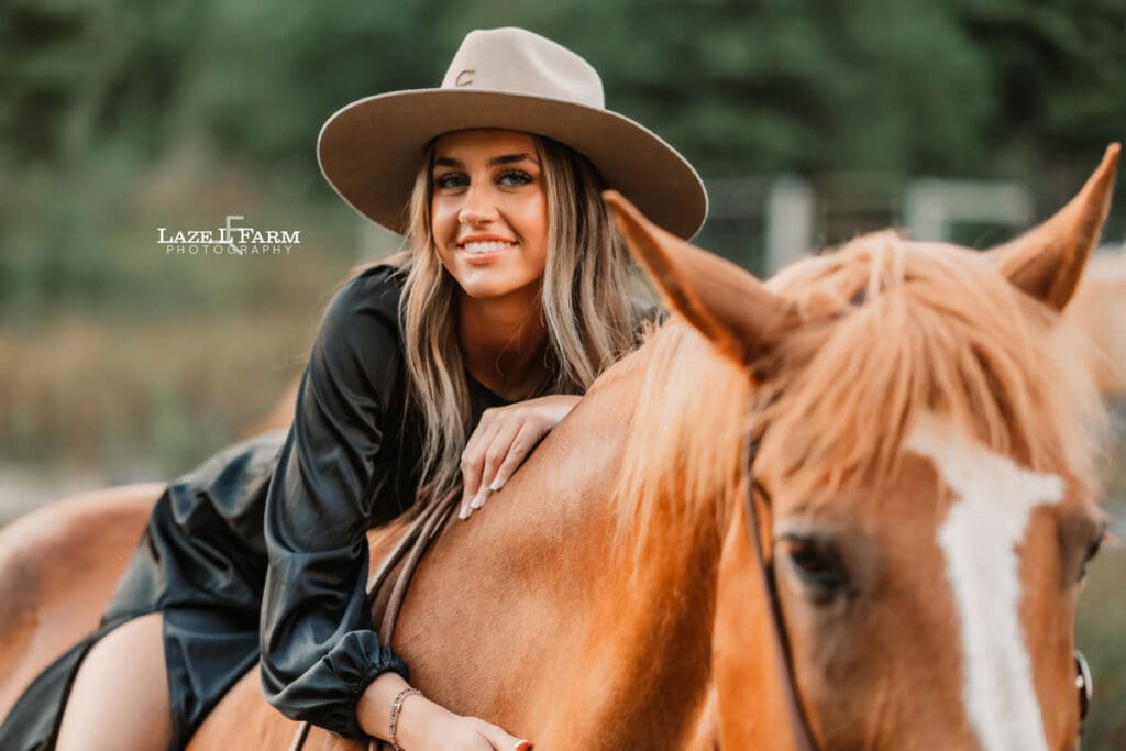 cowgirl laying on the back of a horse during a photoshoot with Laze L Farm Photography