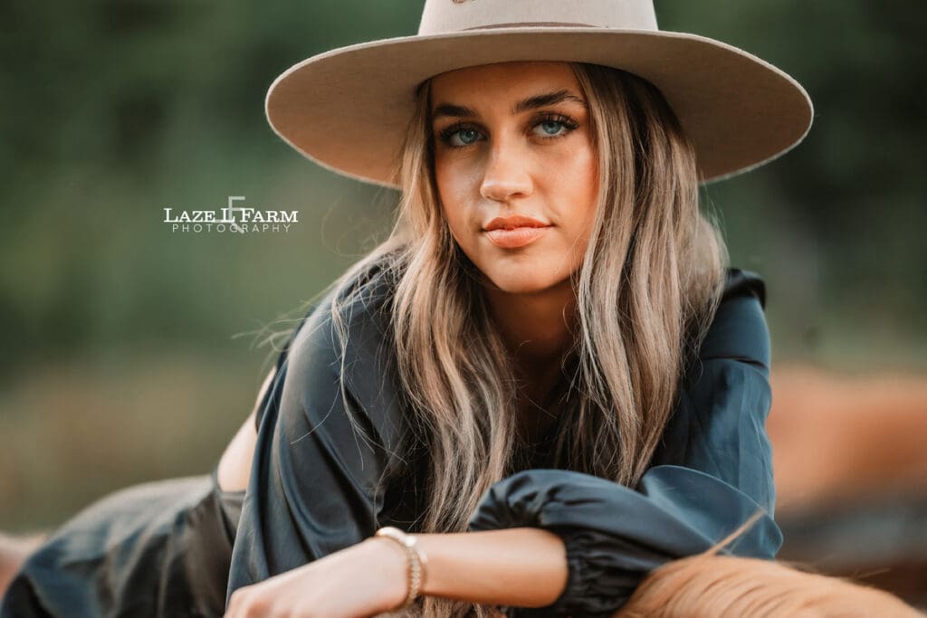 cowgirl laying on the back of a horse during a photoshoot with Laze L Farm Photography