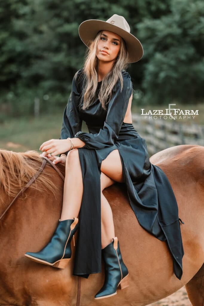 cowgirl sitting on the back of a horse with her legs crossed during an equine photoshoot with Laze L Farm Photography