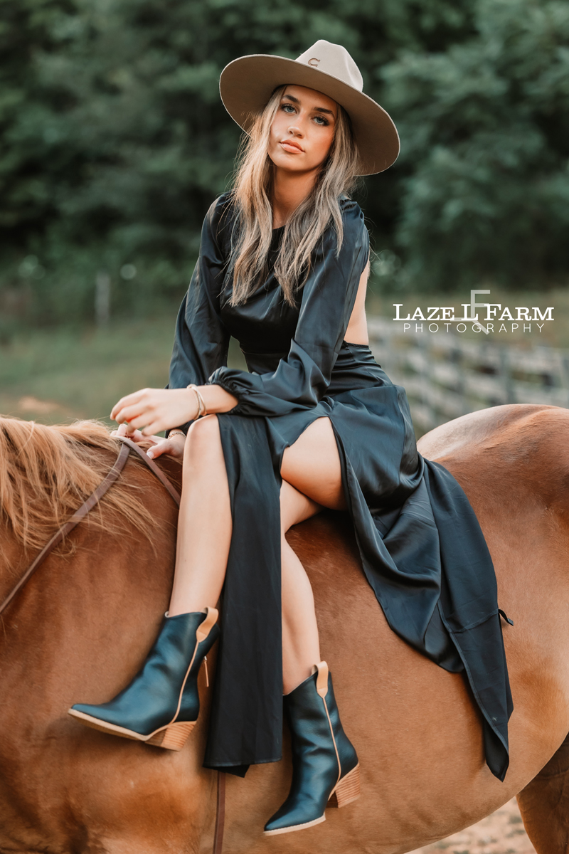 cowgirl sitting on the back of a horse with her legs crossed during an equine photoshoot with Laze L Farm Photography