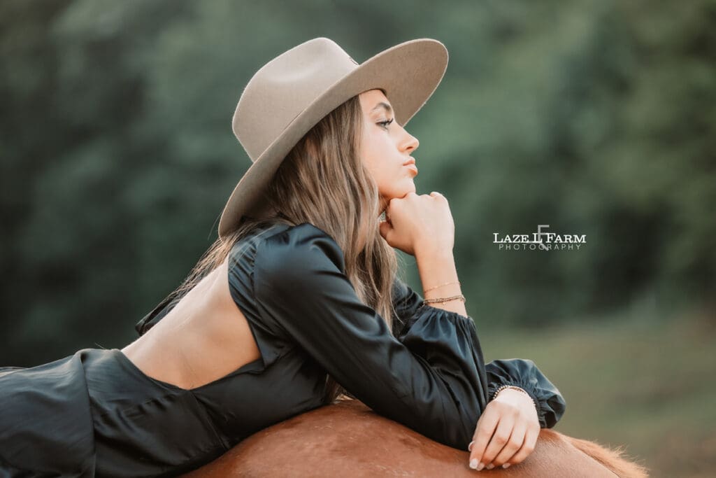 cowgirl laying on the back of a horse during a photoshoot with Laze L Farm Photography