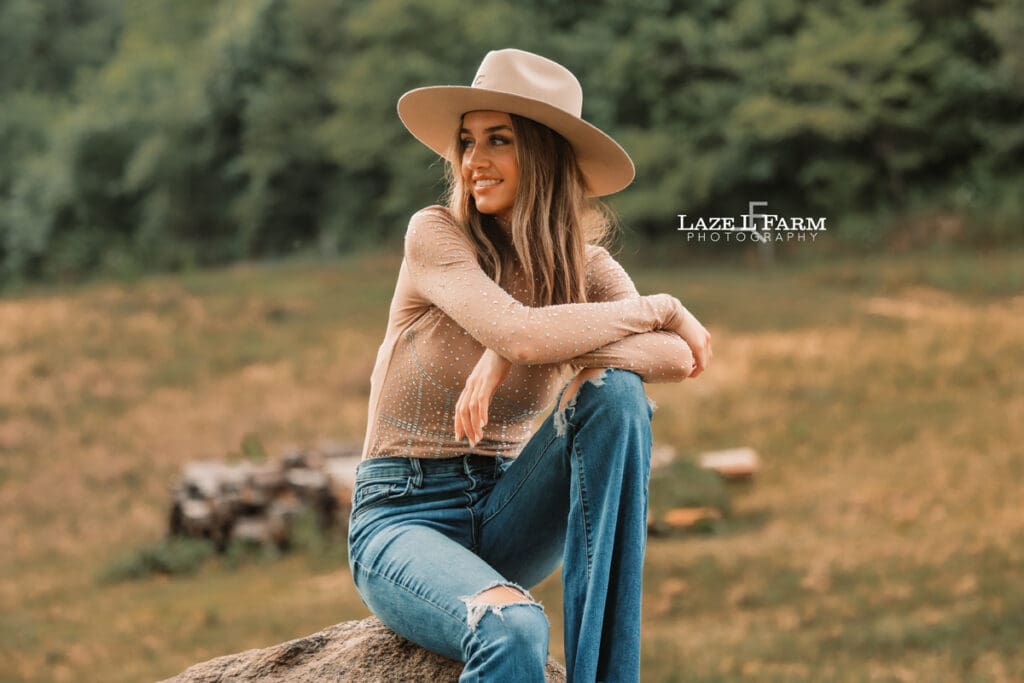 cowgirl leaning against the cattle shoot during a photoshoot with Laze L Farm Photography
