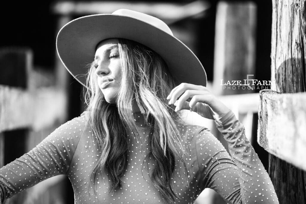cowgirl leaning against the cattle shoot during a photoshoot with Laze L Farm Photography