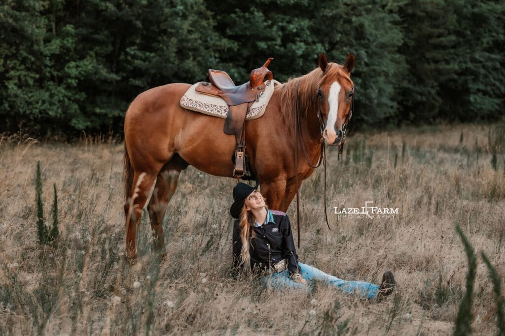 A cowgirl riding her horse in a field at sunset during a photoshoot with Laze L Farm Photography