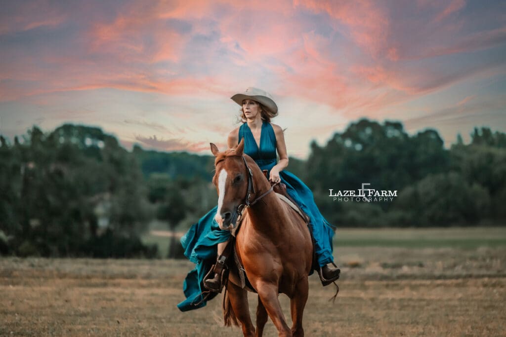 Cowgirl in a turquoise parachute dress at sunset with her horse during a photoshoot with Laze L Farm Photography