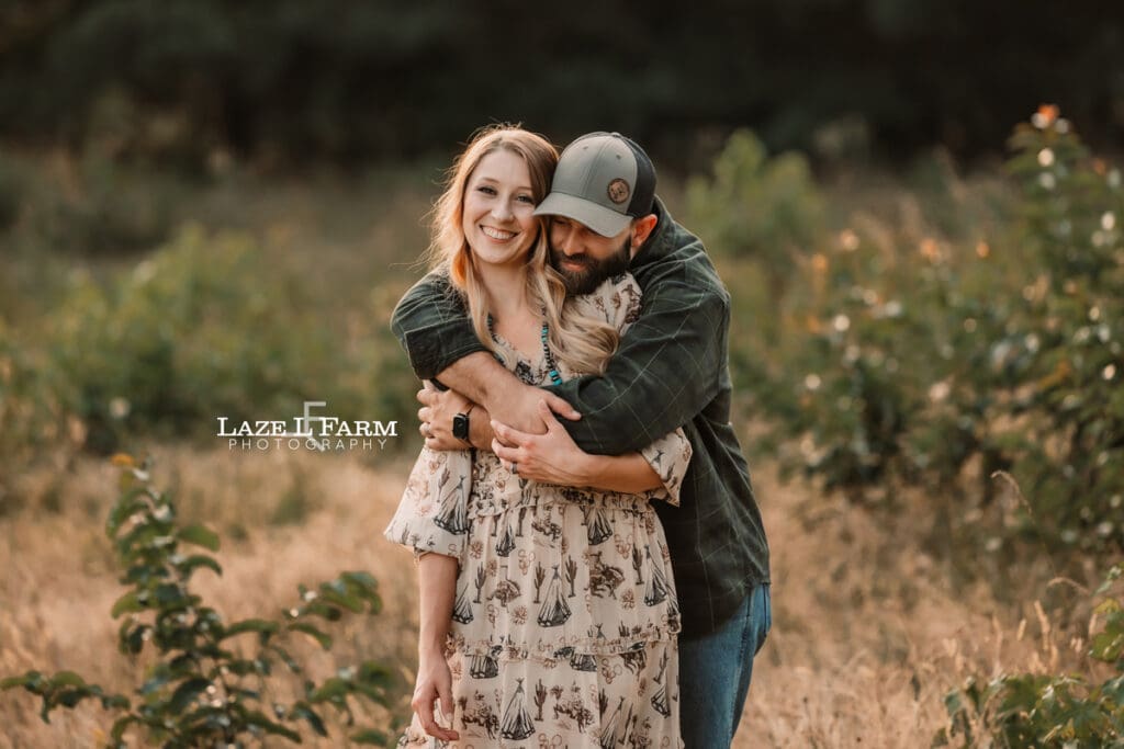 A couple during in a field holding hands at sunset during a photoshoot with Laze L Farm Photography
