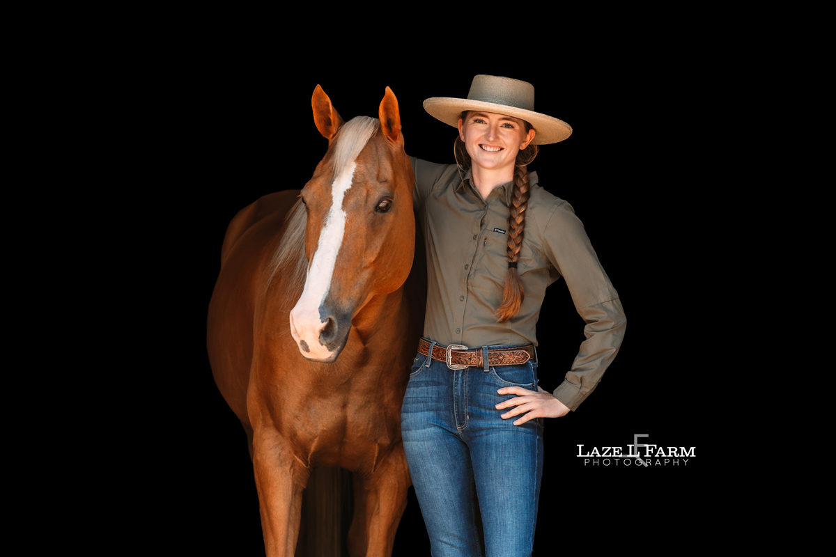 Cowgirl with her horse standing in a barn during her photoshoot with Laze L Farm Photography