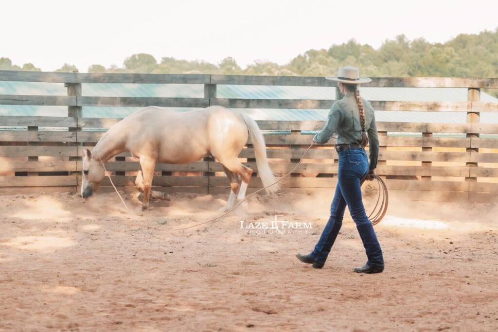 Cowgirl working her horse in the round pen during a photoshoot with Laze L Farm Photography