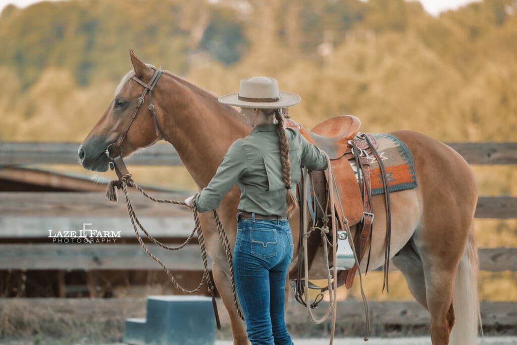 Cowgirl working her horse in the round pen during a photoshoot with Laze L Farm Photography