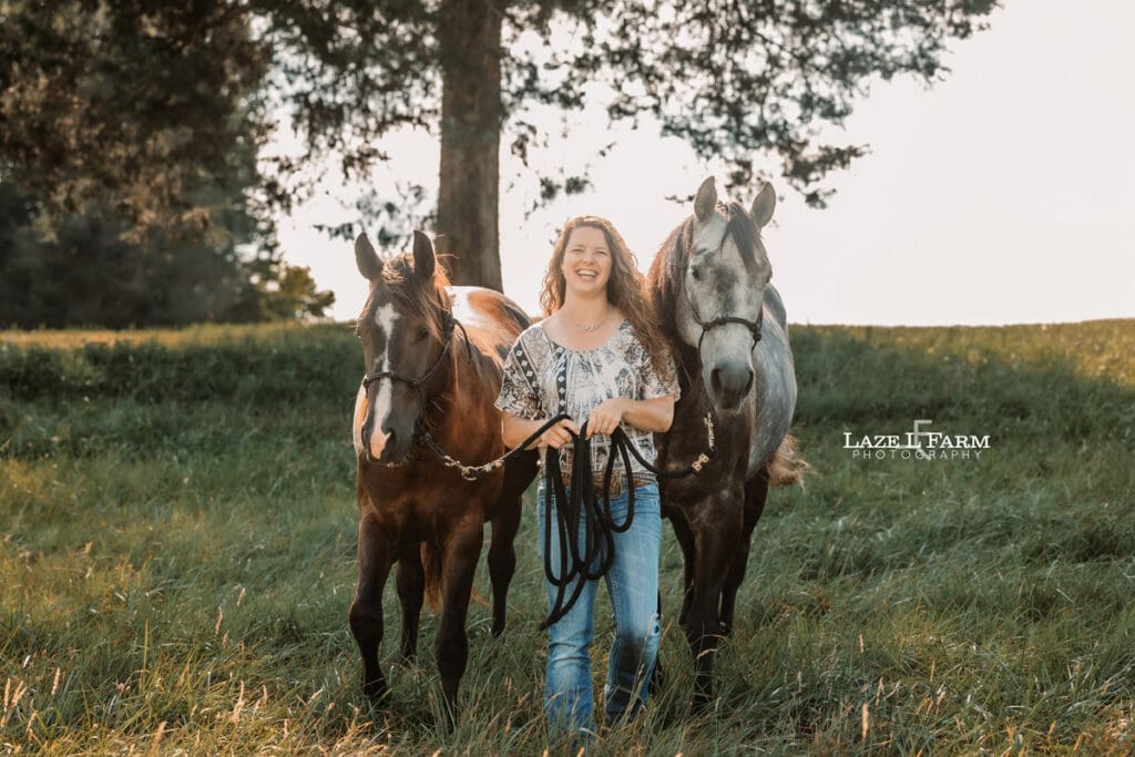 A girl with both of her horses in a field during a photoshoot with Laze L Farm Photography
