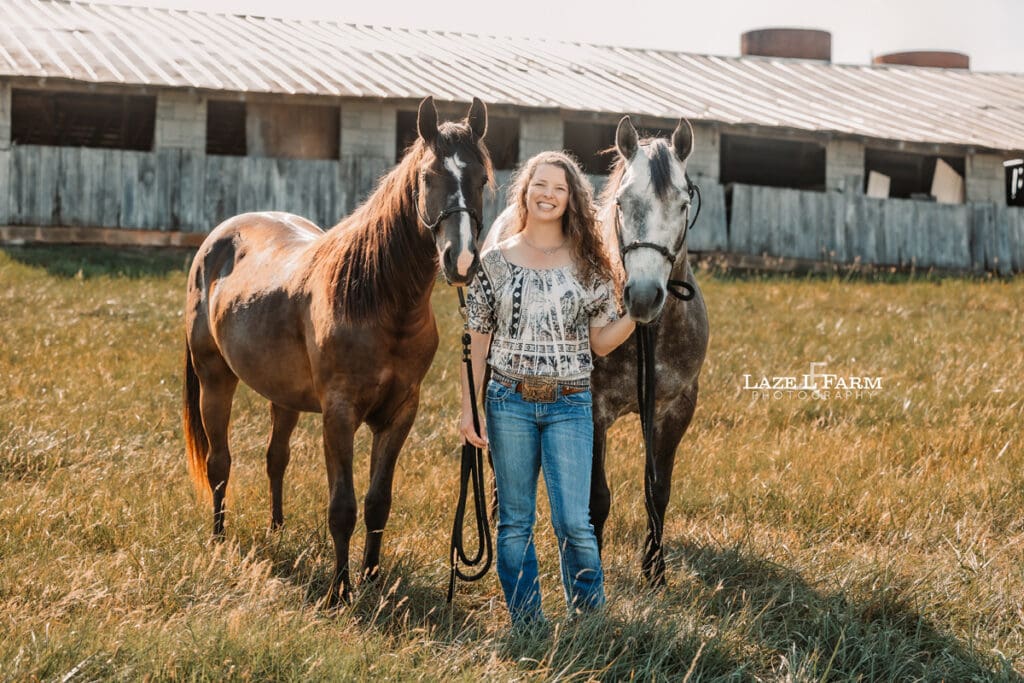 A girl with both of her horses in a field during a photoshoot with Laze L Farm Photography
