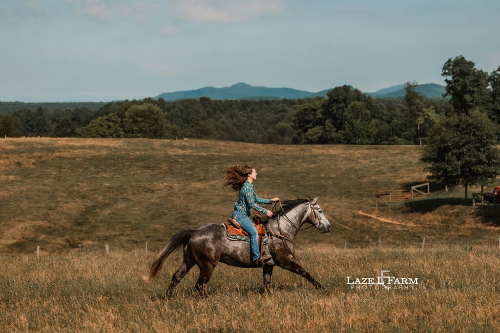 A girl riding her horse in a field during a photoshoot with Laze L Farm Photography