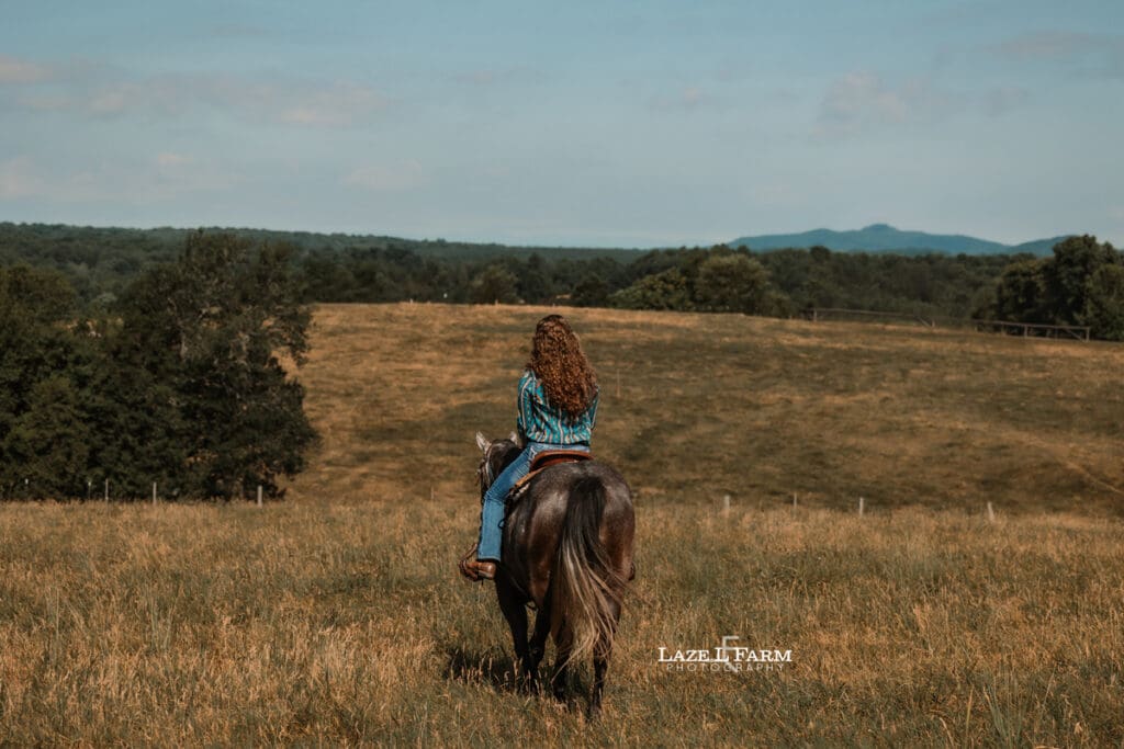 A girl riding her horse in a field during a photoshoot with Laze L Farm Photography