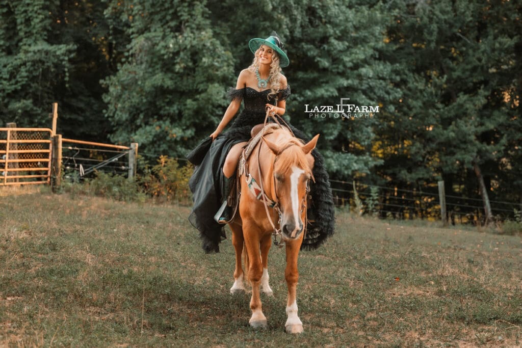 a girl riding a horse in a long black dress at sunset in a field  during a photoshoot with Laze L Farm Photography in Taylorsville NC