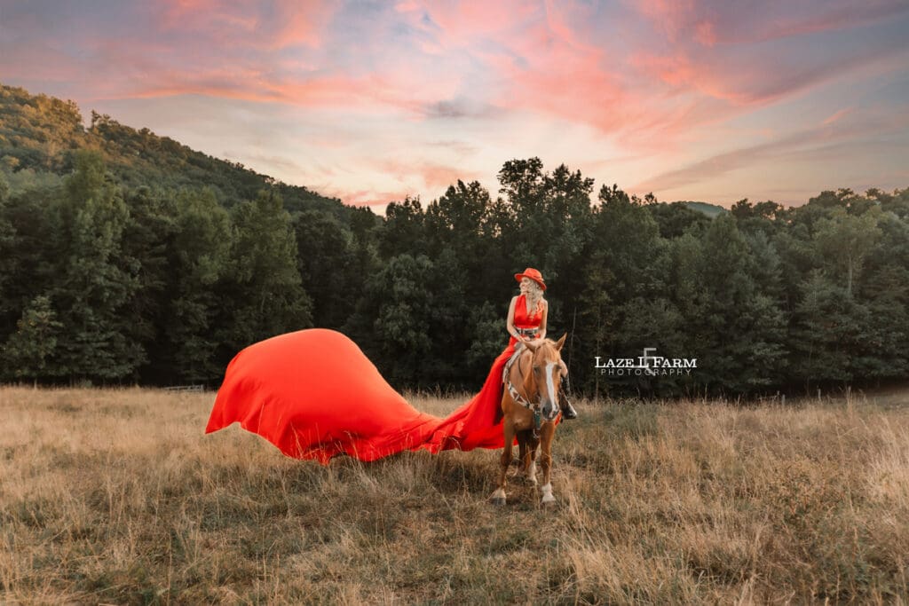 a girl in a red parachute dress at sunset with a horse in a field  during a photoshoot with Laze L Farm Photography in Taylorsville NC