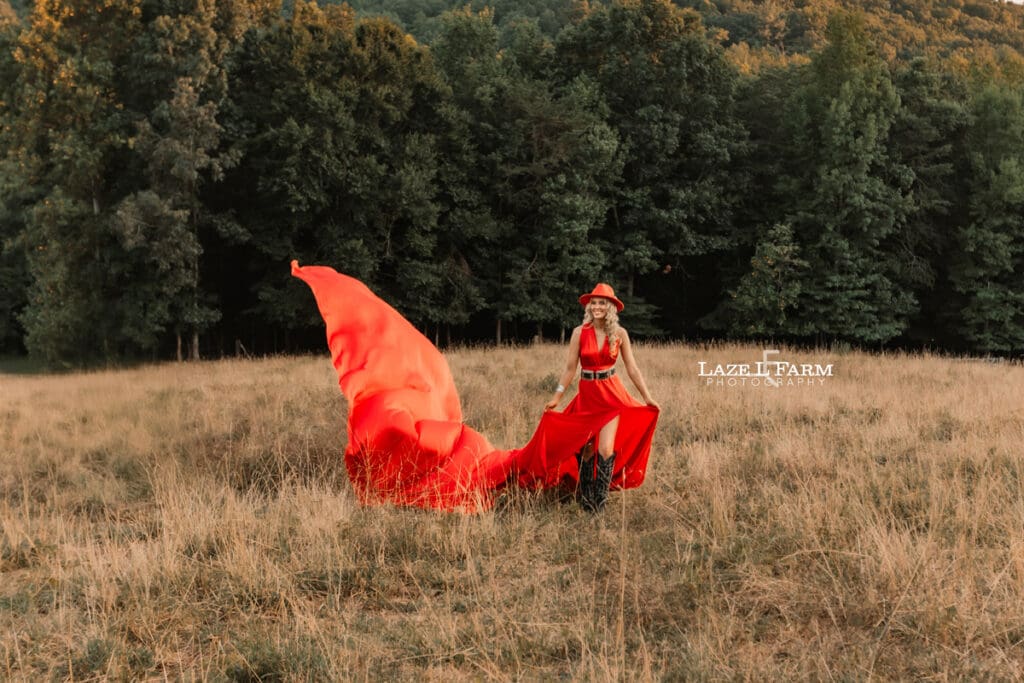 a girl in a red parachute dress at sunset with a horse in a field  during a photoshoot with Laze L Farm Photography in Taylorsville NC